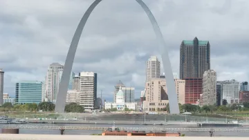 a large arch in front of Gateway Arch